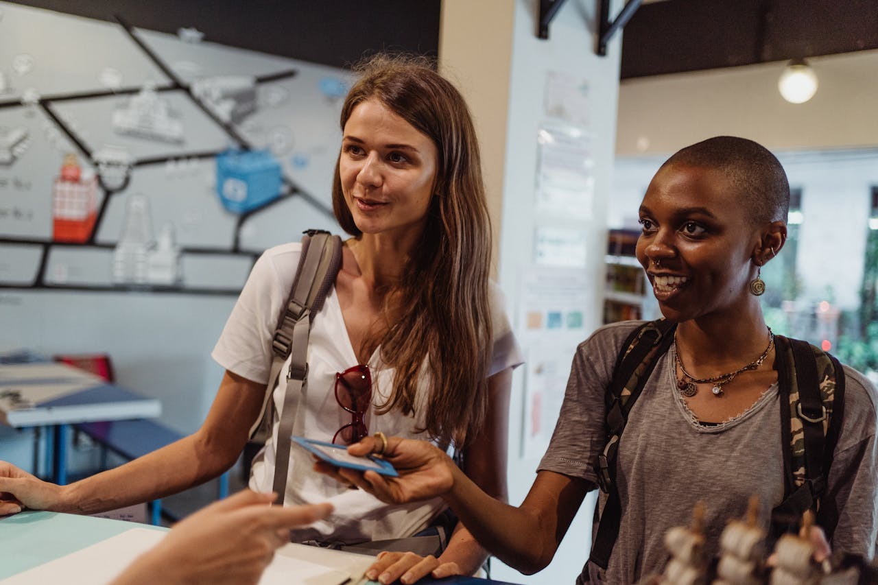 Two women tourists engaging at a hostel reception, offering a friendly atmosphere.